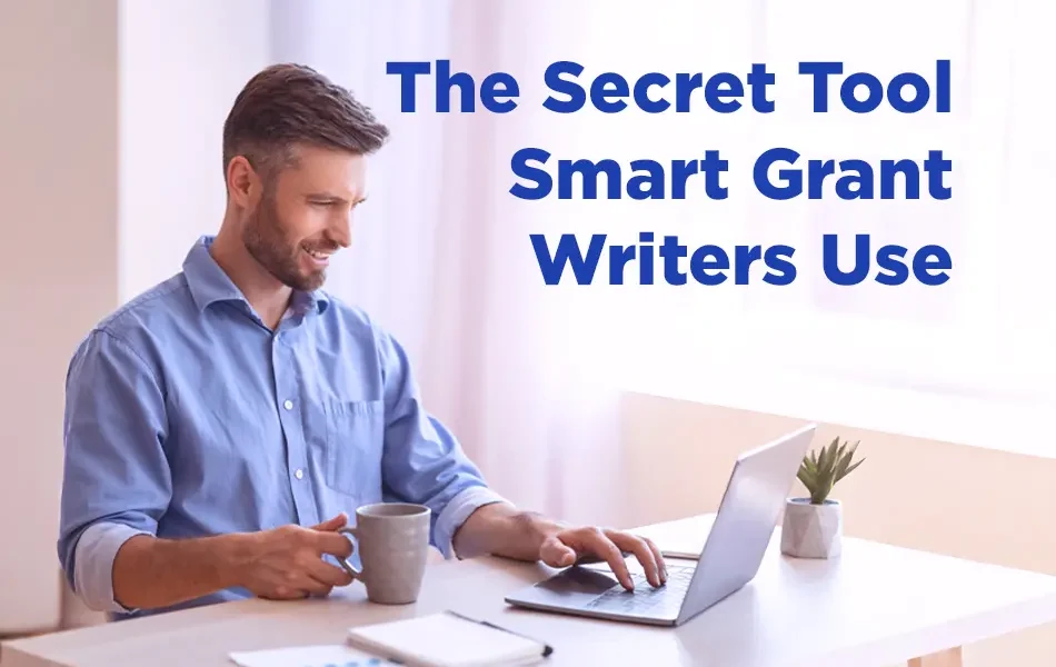 A man sitting at a desk in a bright room, smiling while using a laptop with a coffee mug beside him. Text on the right reads “The Secret Tool Smart Grant Writers Use.”