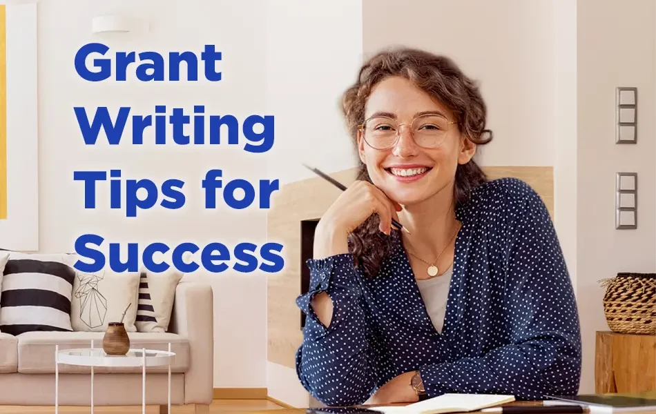 A smiling woman with curly hair and glasses sits at a desk with a notebook and pen, looking confident. Text on the image reads “Grant Writing Tips for Success.” A cozy living room with a sofa and pillows is visible in the background.