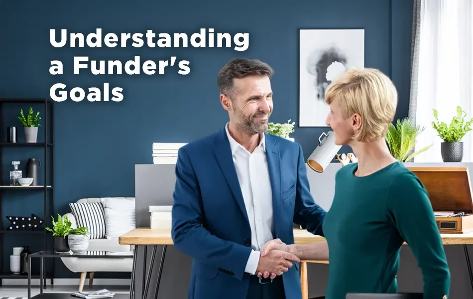 Two professionals shaking hands in a modern office, symbolizing partnership and alignment, with on-screen text reading “Understanding a Funder’s Goals.”