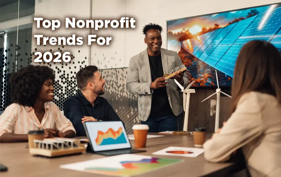 A diverse group of nonprofit board members are meeting in an office setting. It's light, cheerful, and everyone is smiling. A caption reads: "Top Nonprofit Trends for 2026."